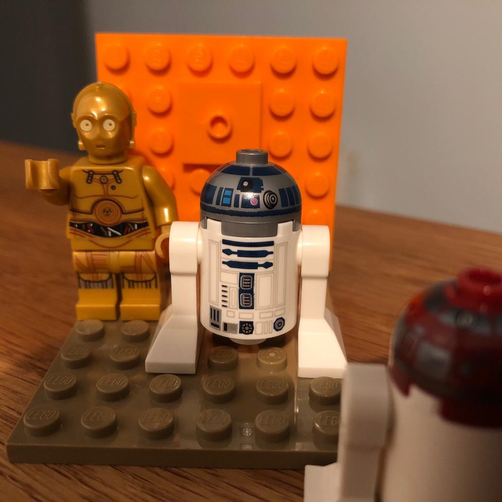 Lego Star Wars C3PO and R2D2 figures on an orange background and brown base