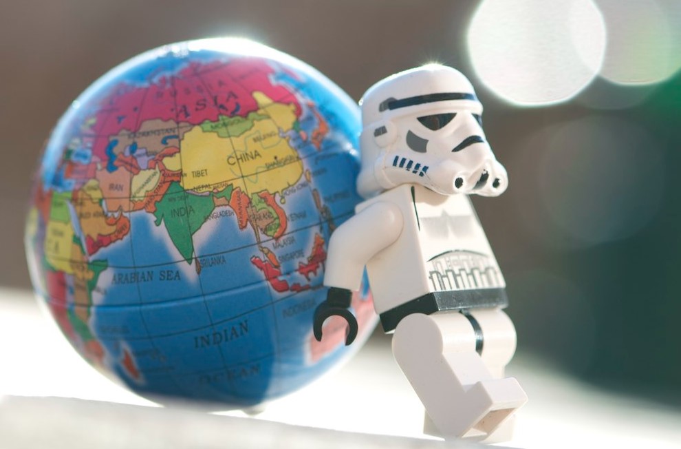 Lego Star Wars stormtrooper pushing a small globe at their back