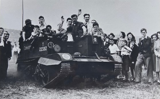 Photo of people riding on a Bren gun carrier. 