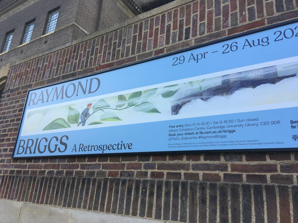 An exhibition poster on a brick wall at Cambridge University Library advertising the Raymond Briggs exhibition