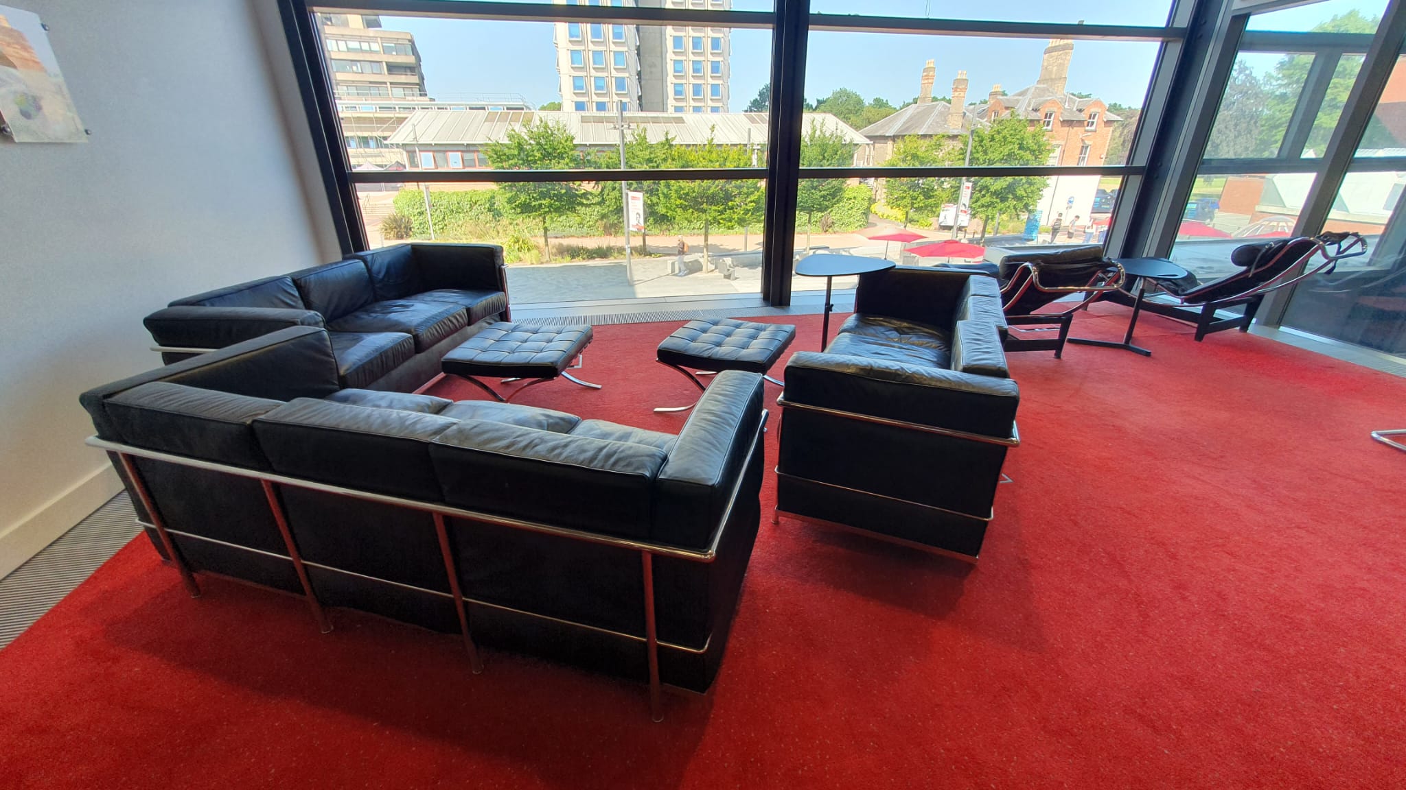 Front of the Doctoral College Reading Room showing leather sofas on a red carpet and large front windows. 