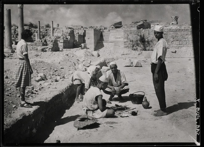 Black and white photograph of an archaeological excavation in Tripolitania; tea is being made in the centre of the ruins.