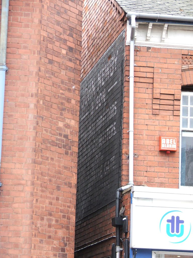 Photo of painted advertisement for John Newby, funeral directors.