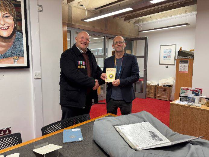 Steve presenting his great-uncle's book Thy Muse Hath Wings to the University Librarian, Steve Williams