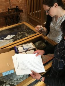 A photo of someone examining the collections at Forge Needle Museum