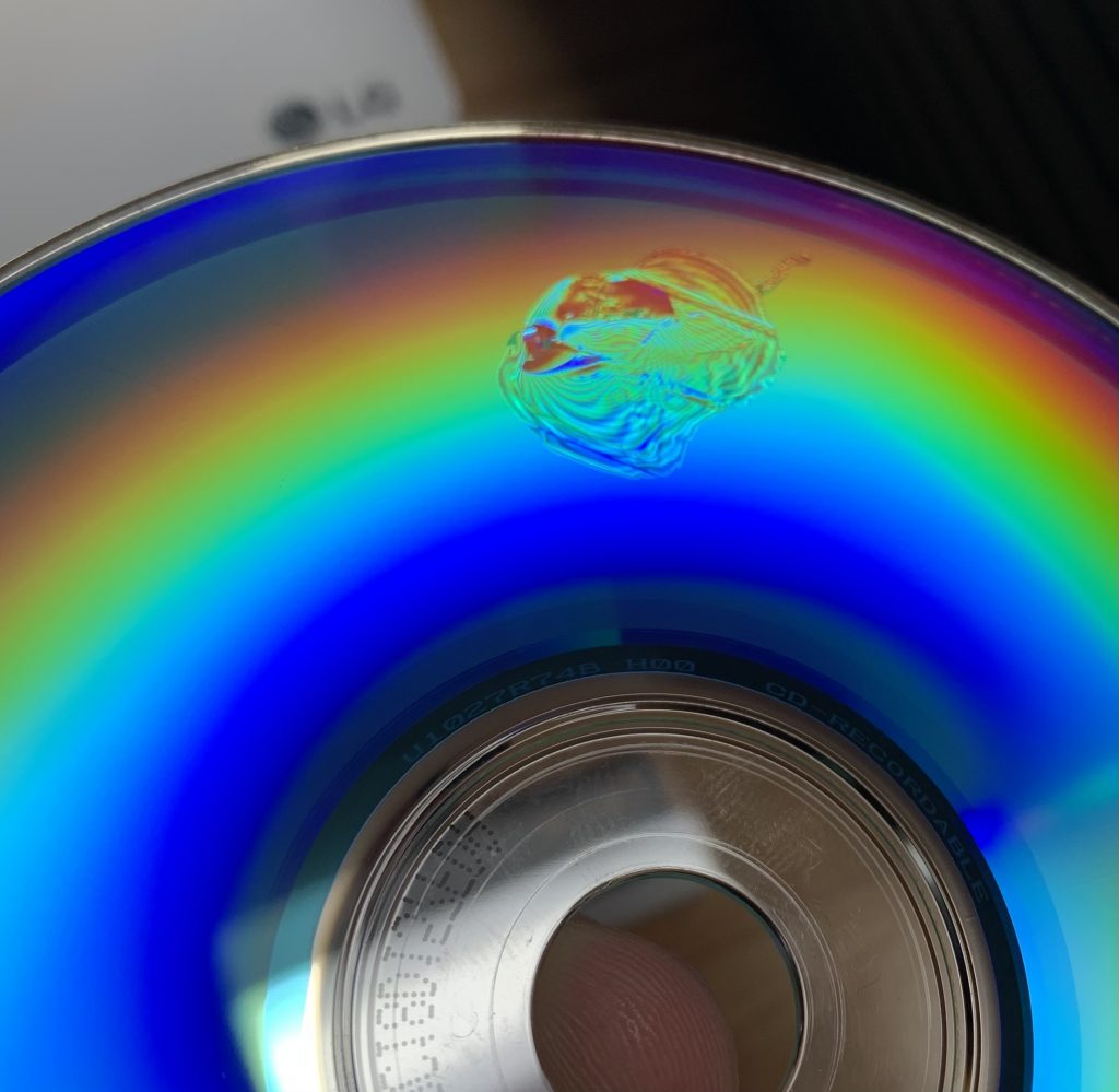 A photo of a CD-R whose surface has been warped by a sticky label.